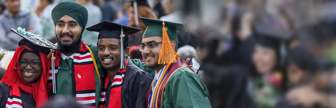 Four graduates smiling